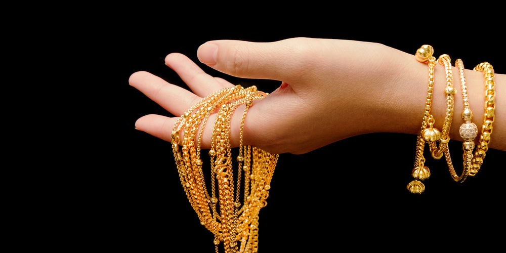 ancient promise beautiful 24k 22k gold bright yellow gold jewelry shiny gold held in womans hand 